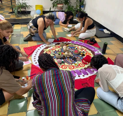 Grupo trabajando alrededor de un mándala colectivo durante una jornada psicosocial