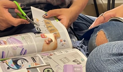 Persona recortando revistas para armar material didáctico