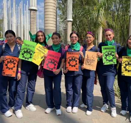 Grupo de jóvenes sosteniendo carteles de colores durante un taller