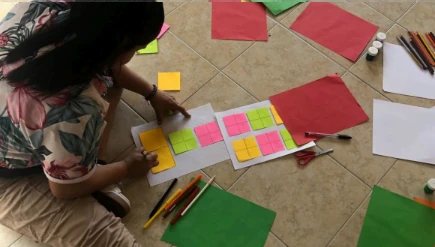 Persona armando un ejercicio creativo con papeles de colores